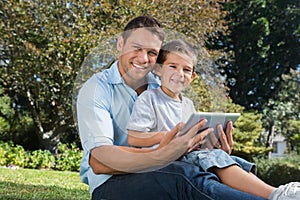 Happy dad and son with a tablet pc