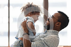 Happy daddy holding kid in arms, hugging toddler boy