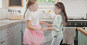 Happy, dance and girl children in the kitchen jumping, playing and bonding in a modern home. Happiness, playful and kid