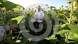 Happy dancer man playing drums withn his hands and dancing energeticly in green summer field.