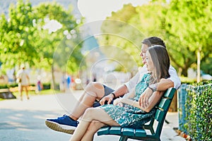 Happy dating couple on a bench in a Parisian park