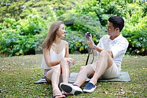 Happy dating couple outdoor picnic with camera