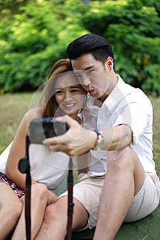 Happy dating couple outdoor picnic with camera