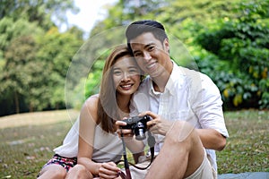 Happy dating couple outdoor picnic with camera