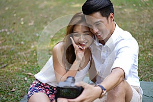 Happy dating couple outdoor picnic with camera