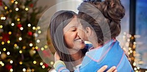 Happy daughter kissing her mother on christmas