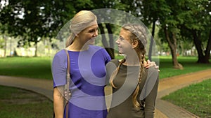 Happy daughter and mother smiling, showing thumbs-up gesture, pleasure pastime