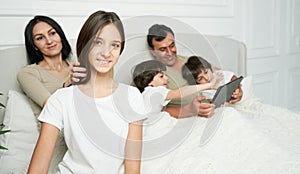 Happy daughter. Portrait of pretty teenage latin girl smiling at camera while spending time with her family in the
