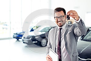 Happy dealer holding car keys