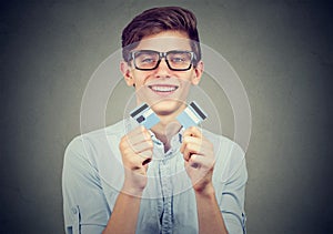 Happy debt free student holding a credit card cut in two pieces