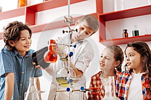 Happy delighted kids experimenting with chemical liquids