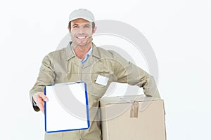 Happy delivery man with box showing clipboard