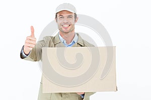 Happy delivery man gesturing thumbs up while carrying cardboard box