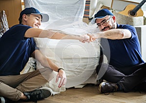 Happy delivery man giving fist bump to each other