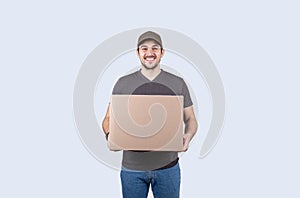 Happy delivery man holding a box package over grey background. Courier Delivering Package Express Delivery Service