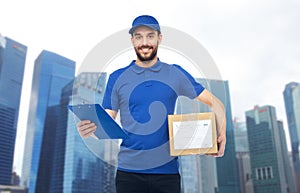 Happy delivery man with parcel box and clipboard