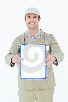Happy delivery man showing blank paper on clipboard