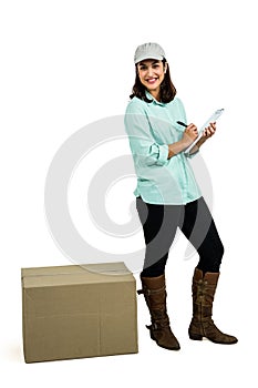 Happy delivery woman with clipboard standing by box