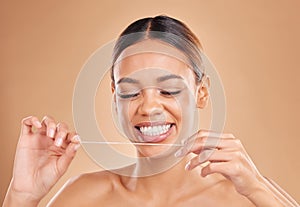 Happy, dental floss and woman in studio for teeth, cleaning and oral hygiene against brown background. Mouth, flossing