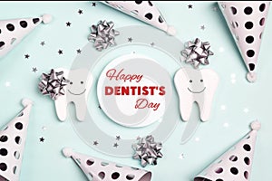 Happy Dentist`s Day greeting card with teeth and holiday caps on a blue