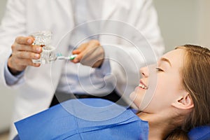 Happy dentist showing jaw layout to patient girl