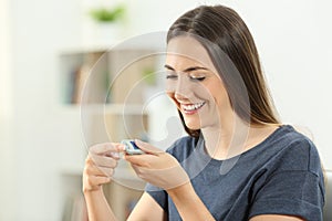 Happy diabetic girl checking blood sugar level photo