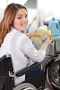 happy disable woman doing washing machine