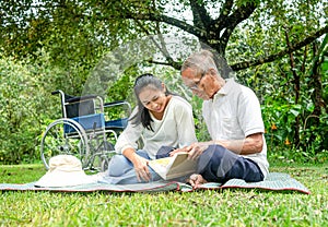 Happy disabled grandfather relaxing with granddaughter outdoor at the park. Family happy lifestyle