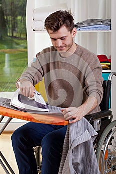 Happy disabled man during ironing