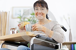 happy disabled senior woman in wheelchair at home