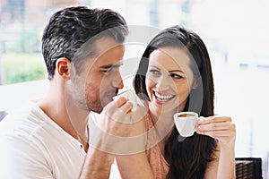 Happy, discussion and couple with coffee on date for romance or anniversary in cafeteria. Love, bonding and young man