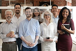 Happy diverse business team standing in office looking at camera photo