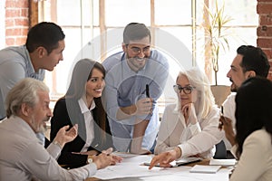 Happy diverse business team talking brainstorming gathered at table