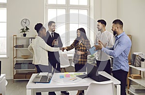 Happy diverse business teams making a deal and shaking hands in an office meeting