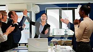 Happy diverse businesspeople giving high five during team corporate brainstorm