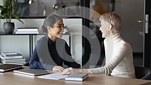 Happy diverse colleagues chatting during break, having pleasant conversation