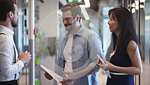 Happy diverse colleagues greeting talking standing in office hall