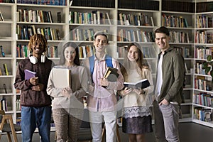 Happy diverse college students posing for group portrait in library