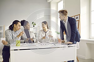 Happy diverse company workers discussing a new business project in a group meeting