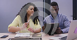 Happy diverse couple of business people working together in modern office