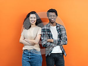 Happy Diverse Couple Smiling With Confidence Against Orange Background