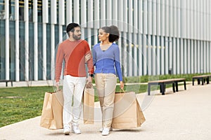 Happy Diverse Couple Walking Carrying Shopping Bags Together Outdoors