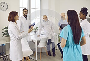 Happy diverse doctors who work in one clinic meet and have a chat in the staff room