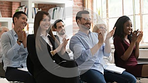 Happy diverse employees applaud thanking speaker for lecture