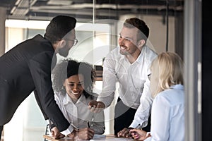 Happy diverse employees brainstorming, discussing project at meeting