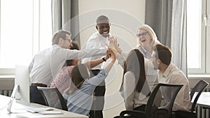 Happy diverse employees business team engaged in teambuilding giving high-five