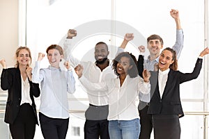 Happy diverse employees celebrating victory and success at work