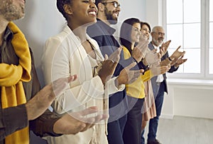 Happy diverse employees clap hands show acknowledgement photo