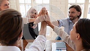 Happy diverse employees team giving high five close up