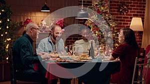 Happy diverse family members enjoying traditional home cooked food wihle celebrating winter holiday